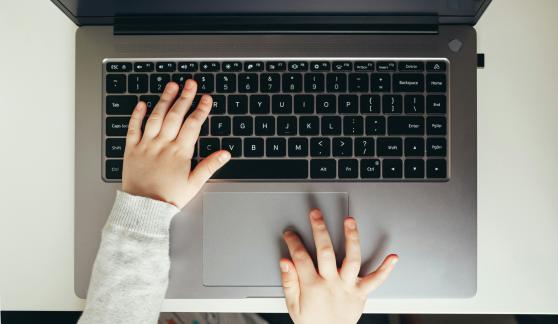Child typing on laptop