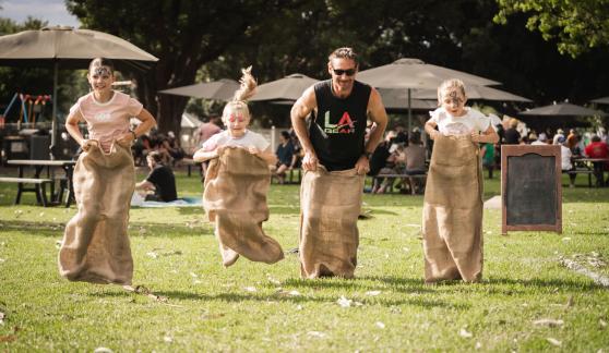 Family of four having a potato sack race