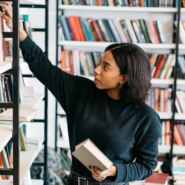 Women placing book on a shelf