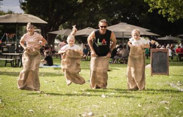Family of four having a potato sack race
