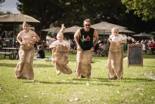 Family of four having a potato sack race